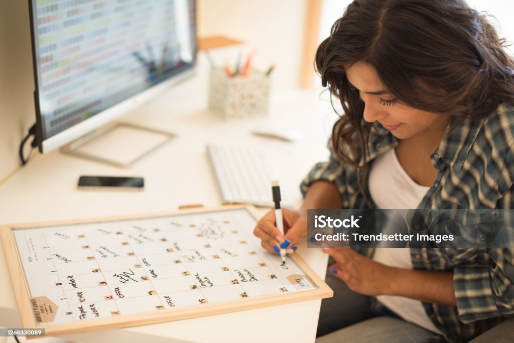 Woman wrinting on calendar Woman on computer desk wrinting on calendar Calendar Stock Photo