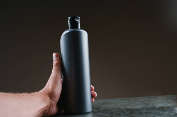 istock mockup of gray plastic bottle in hands on a dark background 1264331967