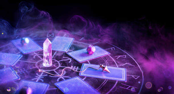 Tarot Cards And Pendulum On Altar Cartomancy - Pendulum On Blurred Altar With Defocused-Tarot Cards And Smoke crystal altar stock pictures, royalty-free photos & images