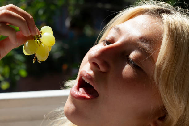 istock young girl eating grapes 1264332479