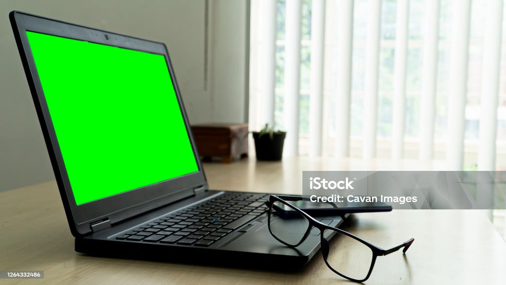 laptop on wooden desk with green screen glasses and smartphone w laptop on wooden desk with green screen glasses and smartphone w in Monterrey, N.L., Mexico Business Stock Photo