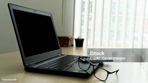 Laptop On Desk In Office With Lenses And Smarphone Espac Stock Photo - Download Image Now