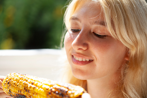young girl eating corn