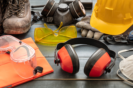 Work safety protection equipment. Industrial protective gear on wooden table background, closeup view. Construction site health and safety concept