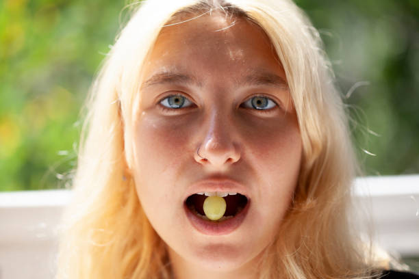 young girl eating grapes
