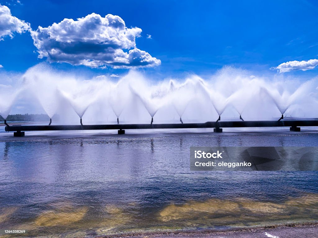 A colorful sight: cooling fountains of the Atomic Station, Heat of a power plant against a background of white clouds, blue sky. A colorful sight: cooling fountains of the Atomic Station, Heat of a power plant against a background of white clouds and blue sky. Air Pollution Stock Photo