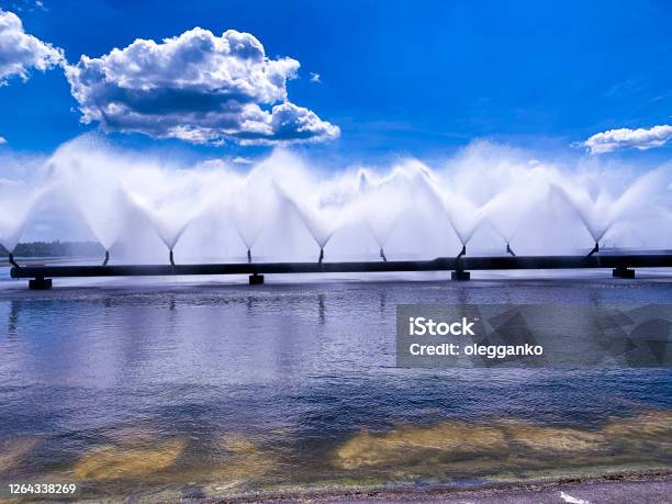 A Colorful Sight Cooling Fountains Of The Atomic Station Heat Of A Power Plant Against A Background Of White Clouds Blue Sky Stock Photo - Download Image Now