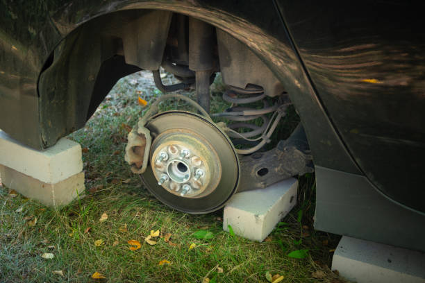 close up of car on bricks outside. concept of stolen vehicle wheels. car with missing wheel. - wooden hub imagens e fotografias de stock