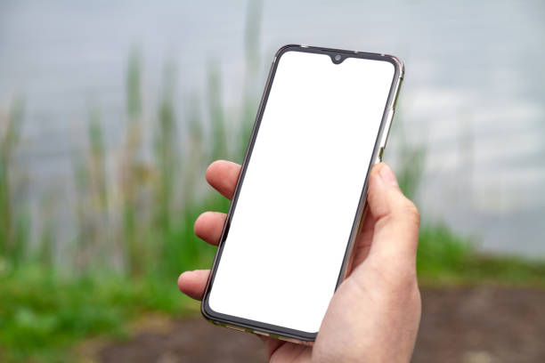 istock A man uses his smartphone on the shore of a pond 1264339501