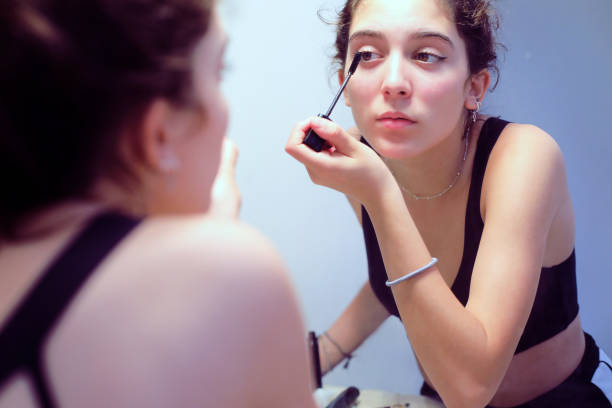 istock Girl applying  makeup in front of the mirror 1264344187