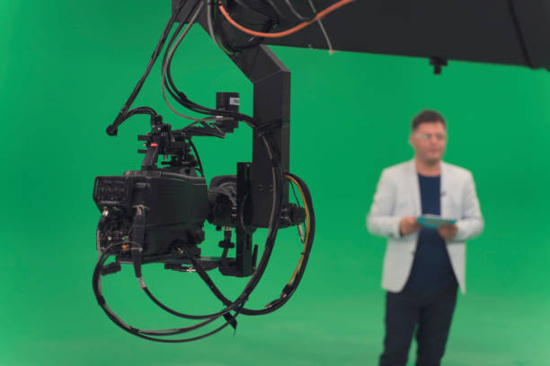 istock Broadcast television studio camera in green screen studio room with announcer on the ceiling. 1264345391