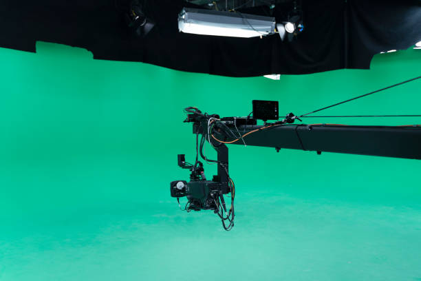 istock Broadcast television studio camera jib in green screen studio room with LED lights on the ceiling. 1264345422