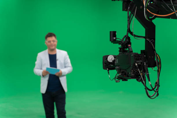 Broadcast television studio camera in green screen studio room with announcer on the ceiling. Film Set, Studio - Workplace, Lighting Equipment, Broadcasting, Camera - Photographic Equipment jib stock pictures, royalty-free photos & images