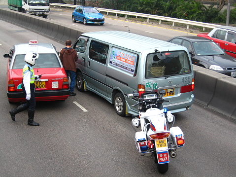 Police survey the scene of the car accident in Chatham Road, Kowloon, Hong Kong.