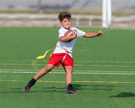 Action shots of a very young and athletic boy playing flag football