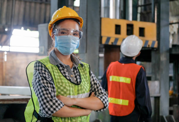 istock Factory woman engineer worker or technician with hygienic mask stand with confident action 1264352940