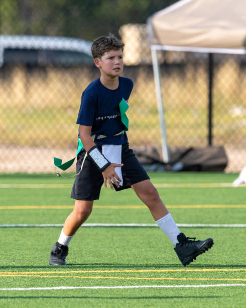 istock Young boy playing in a flag football game 1264354302