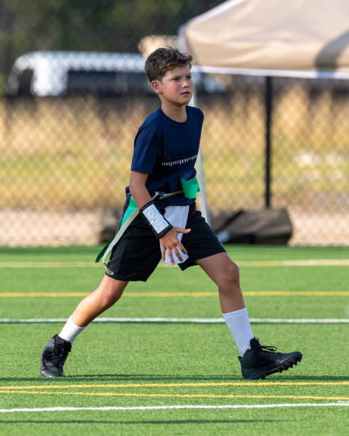 istock Young boy playing in a flag football game 1264354812