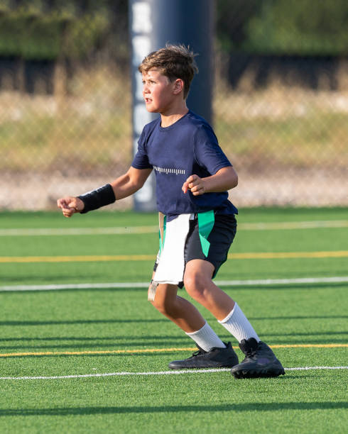 istock Young boy playing in a flag football game 1264354855