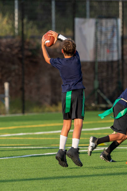istock Young boy playing in a flag football game 1264354860