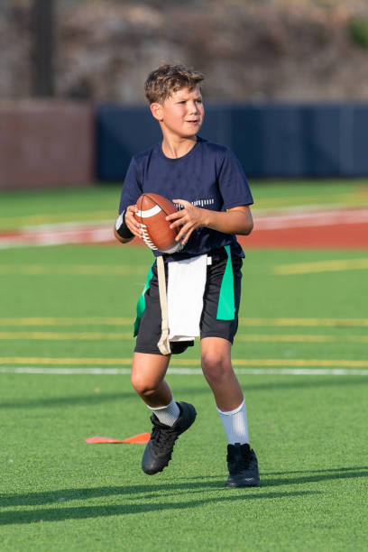 istock Young boy playing in a flag football game 1264354871