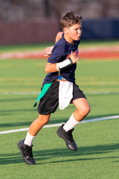 istock Young boy playing in a flag football game 1264354960