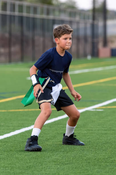 istock Young boy playing in a flag football game 1264355010