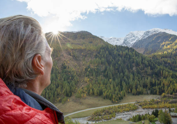 istock Hiker watches sun rise over distant mountain range 1264358253