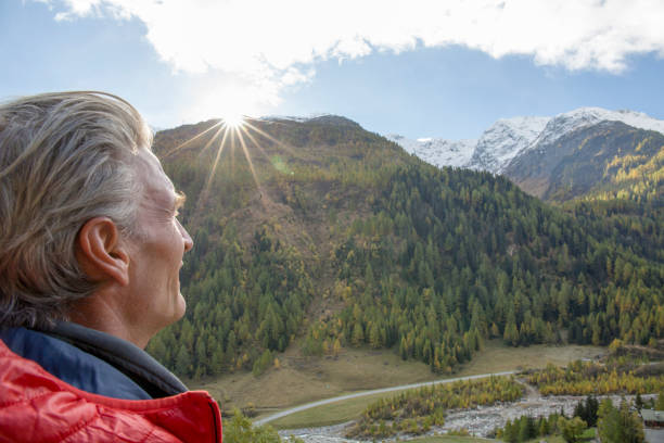 istock Hiker watches sun rise over distant mountain range 1264358375