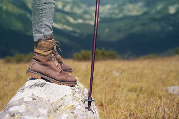 istock woman with leather boots and hiking stick on mountain 1264360117