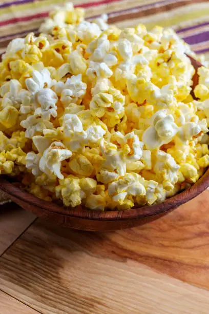 Homemade theater popcorn with butter in wooden bowl for movie night