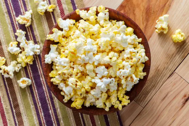 Homemade theater popcorn with butter in wooden bowl for movie night