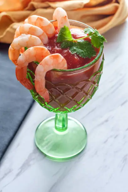 Delightful tail-on shrimp cocktail served with horseradish dipping sauce in glass cup