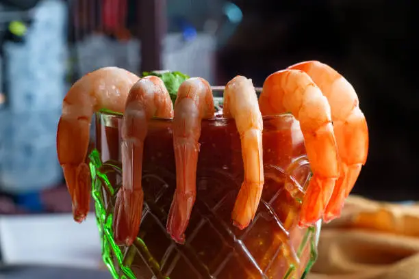 Delightful tail-on shrimp cocktail served with horseradish dipping sauce in glass cup