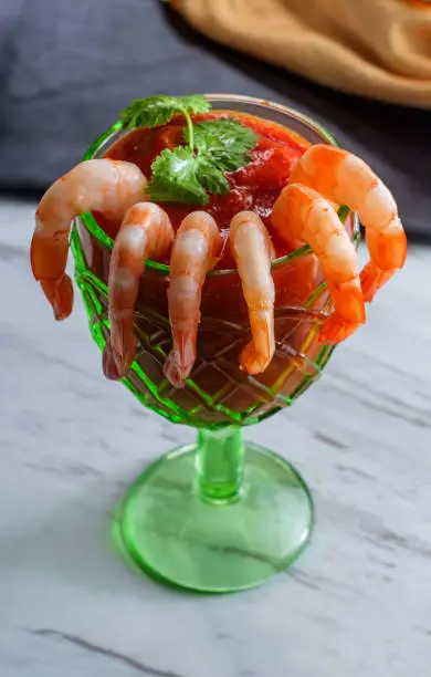 Delightful tail-on shrimp cocktail served with horseradish dipping sauce in glass cup