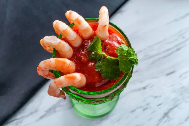 Delightful tail-on shrimp cocktail served with horseradish dipping sauce in glass cup