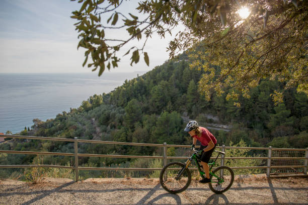 istock Mountain biker rides up coastal road 1264362266