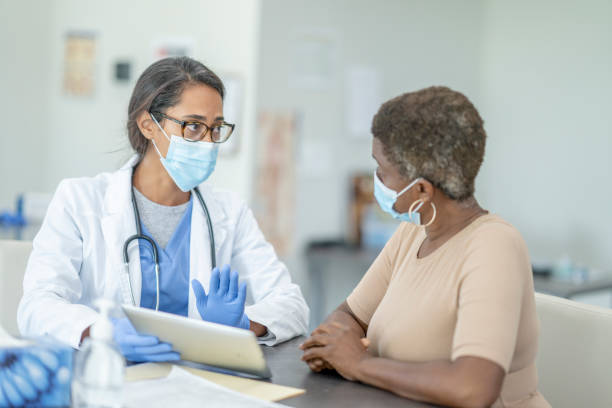 Doctor and patient in medical exam Female doctor and patient in personal protective equipment at medical exam. protective glove photos stock pictures, royalty-free photos & images
