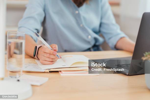 Working From Home Hand Of A Businesswoman Writing Notes Stock Photo - Download Image Now