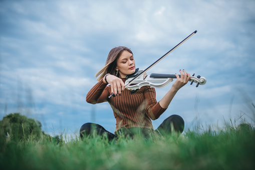 Young woman playing the violin at park