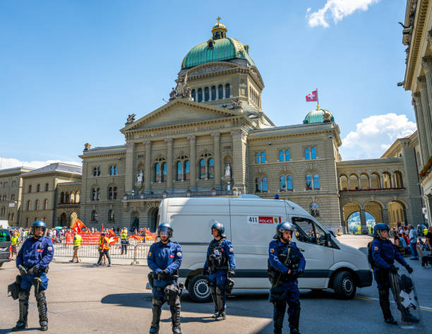 швейцарские полицейские и полицейский фургон на федеральной площади перед зданием федерального парламента в берне, швейцария - berne canton фотографии стоковые фото и изображения