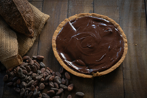 Chocolate pie composition with dry cocoa beans and cacao fruit.