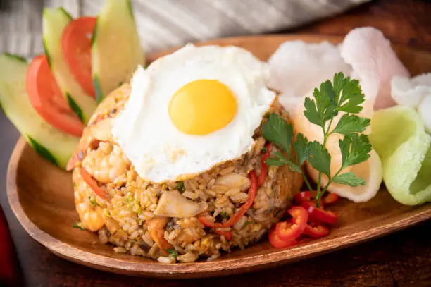 Photo of nasi goreng, indonesian fried rice on wooden plate