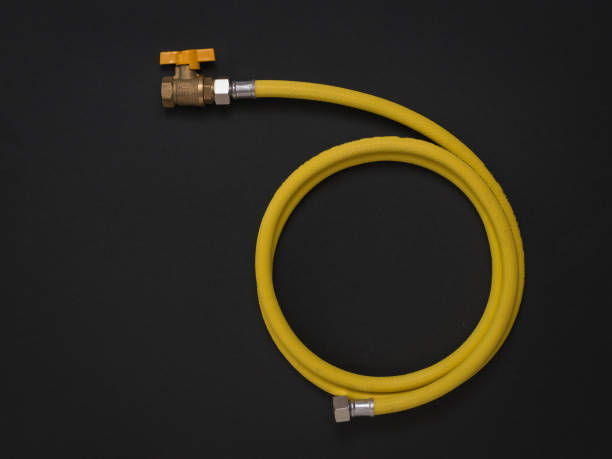 istock Yellow gas hose with a tap on a black background. 1264395551