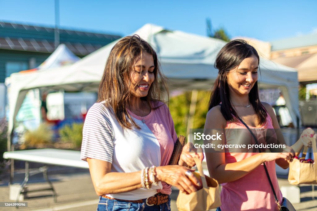 Two Female Friends Enjoying a Farmer's Market Together In Western Colorado Two Female Friends Enjoying a Farmer's Market Together Series with Matching 4k video series (Shot with Canon 5DS 50.6mp photos professionally retouched - Lightroom / Photoshop - original size 5792 x 8688 downsampled as needed for clarity and select focus used for dramatic effect) Family Stock Photo
