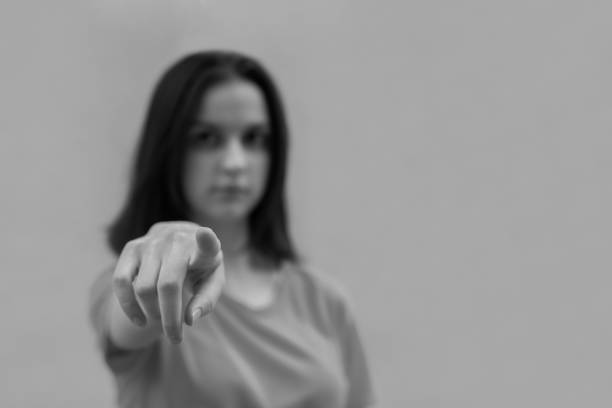 istock Smiling girl using a touch screen interface with index finger, black and white, selective focus 1264406577
