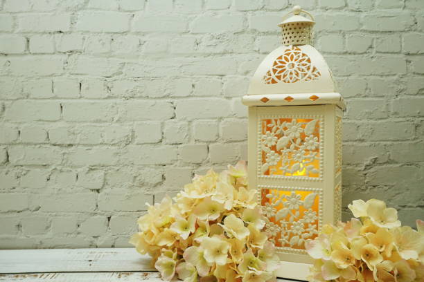 istock White metal lantern with Candle light Decoration on white brick wall background 1264416051