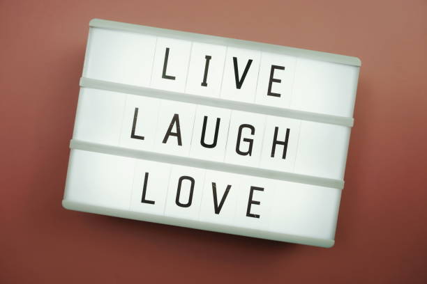istock Live Laugh Love word in light box flat lay on pink background 1264416217