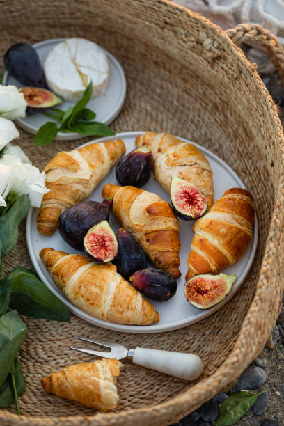 Summer breakfast with croissants and figs in a basket.