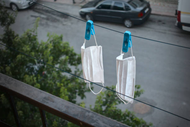 Washed surgical masks hanged up with pegs on the rope to dry stock photo
